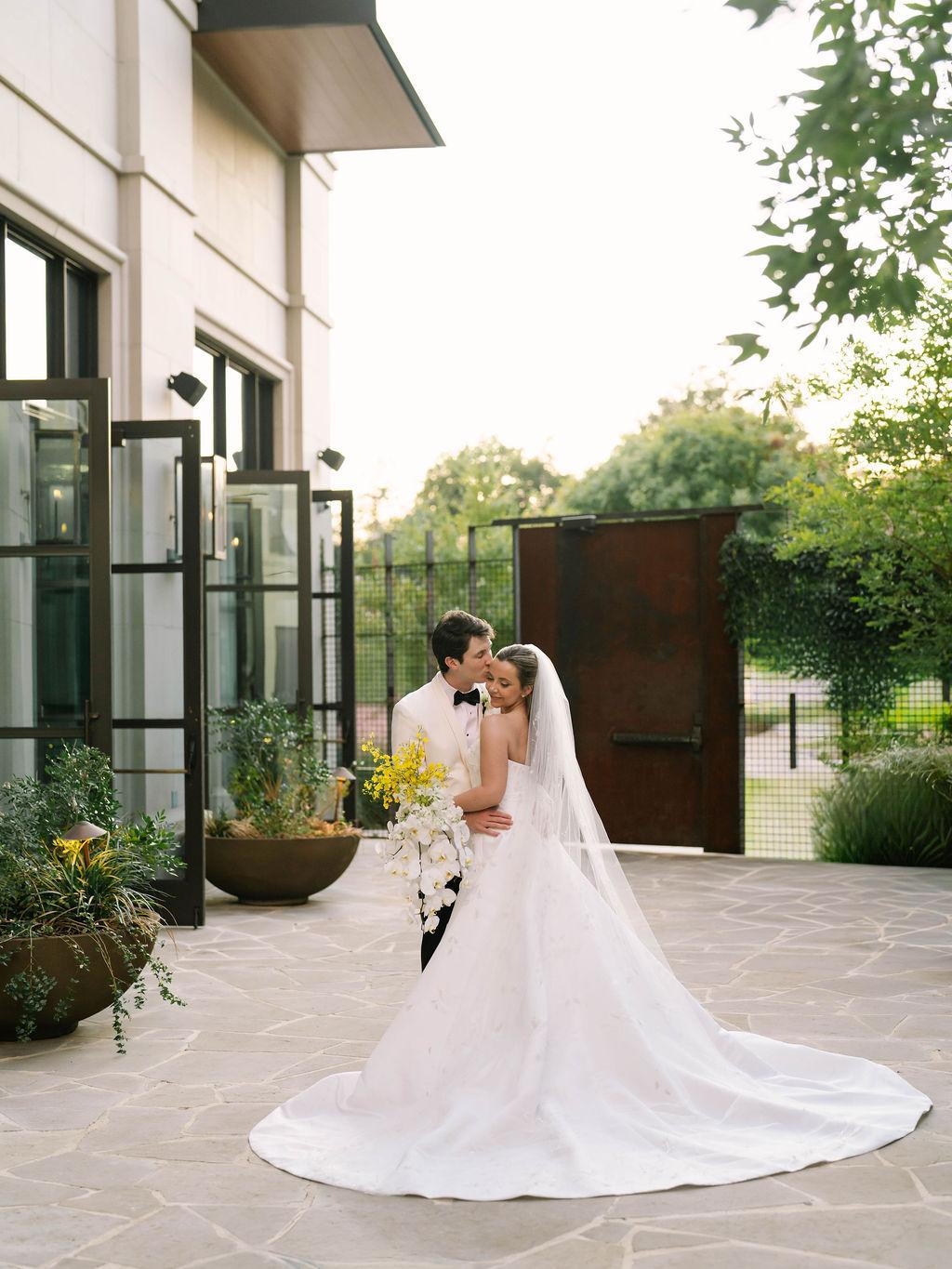 Couple embracing in a garden doorway at golden hour