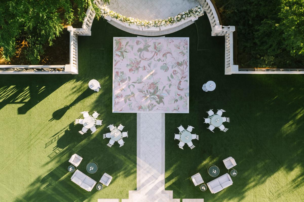 Overhead view of an outdoor cocktail area with a painted floral dance floor and lounge furniture