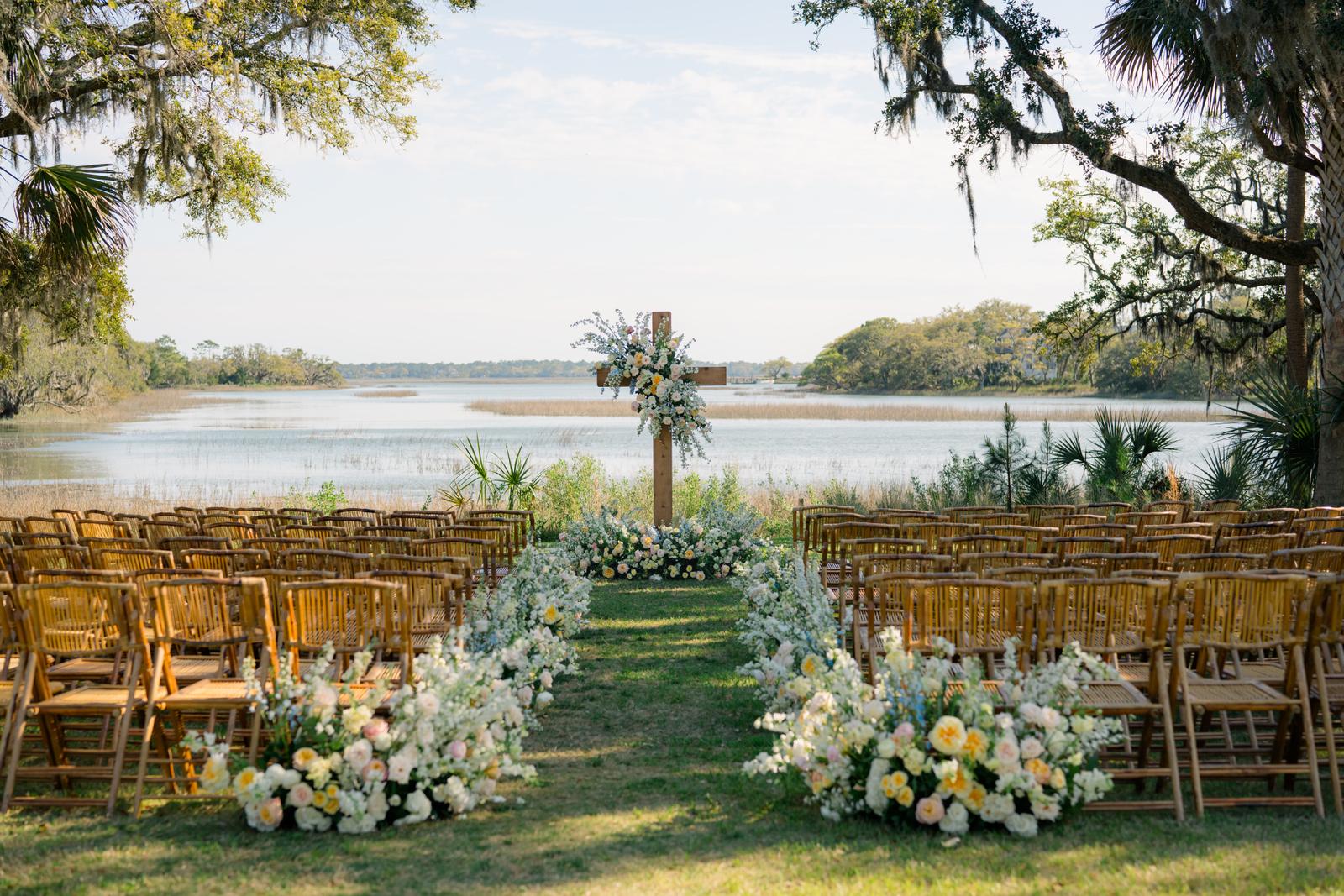 Wedding ceremony set up with florals under live oaks at The Dunlin in South Carolina