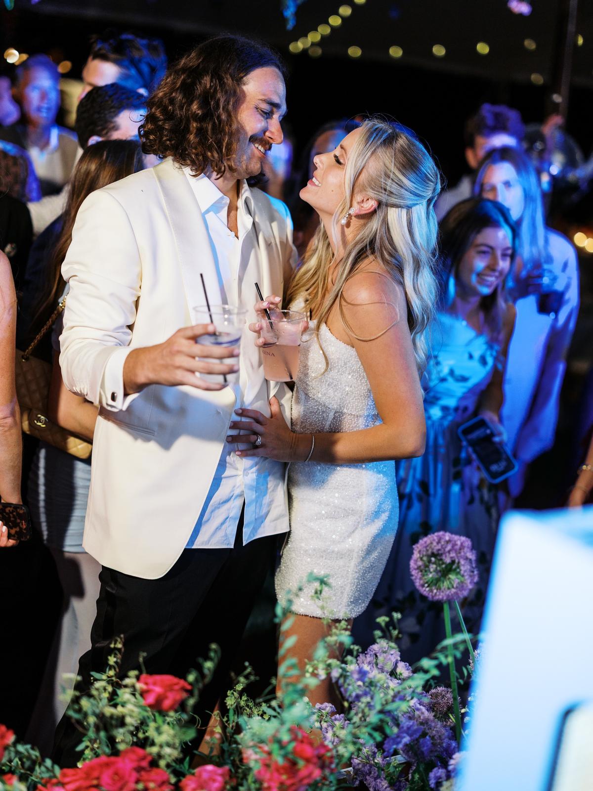 The couple dancing closely under blue light at the reception