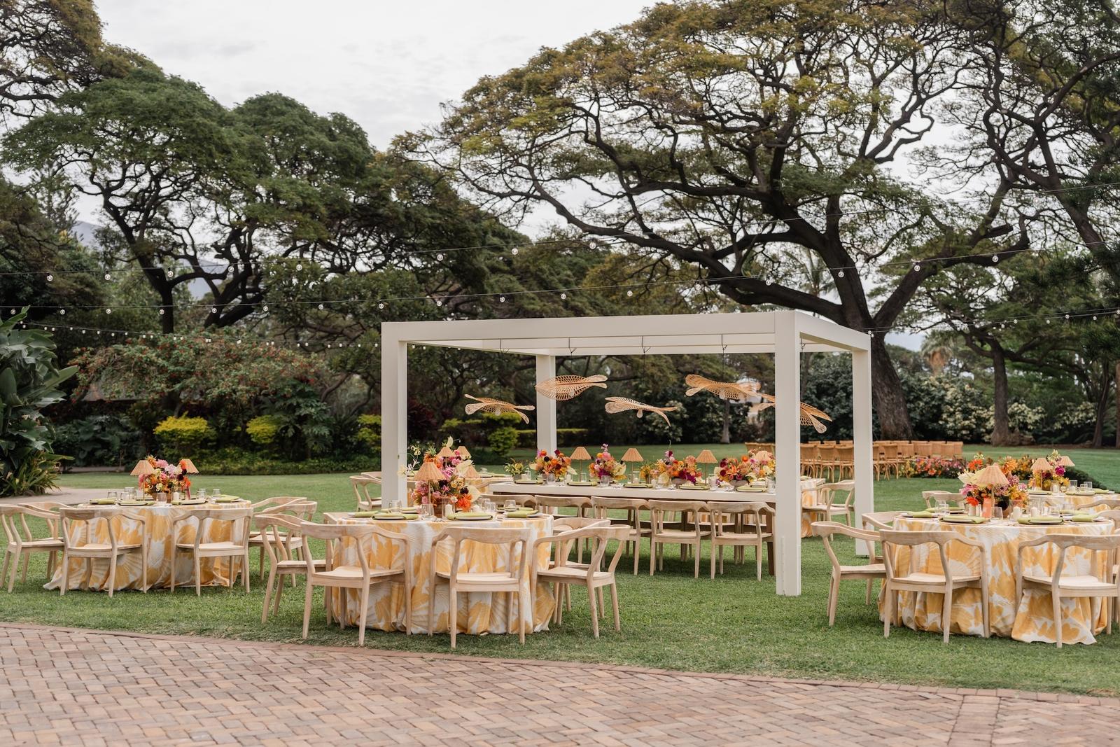Reception tables under white pavilions on a lawn at Olowalu Plantation House