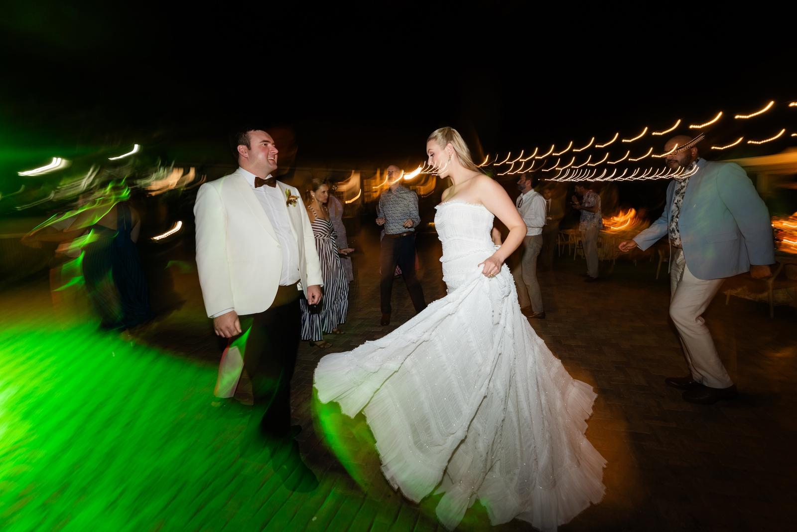 The couple dancing on a lit dance floor at night